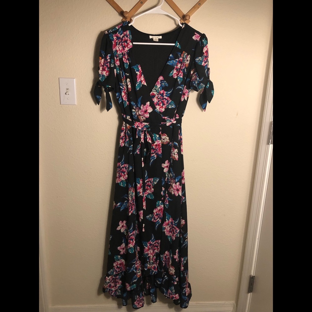 Floral wrap dress with a subtle high low hem. V-neck and tied sleeve detail.